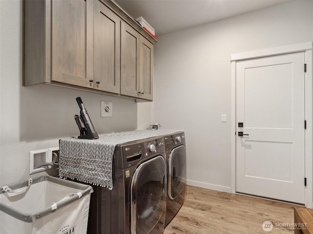 904 E Tanoak Ave, La Center, WA 98629 - clothes washing area with cabinet space, washing machine and clothes dryer, light wood finished floors, and baseboards