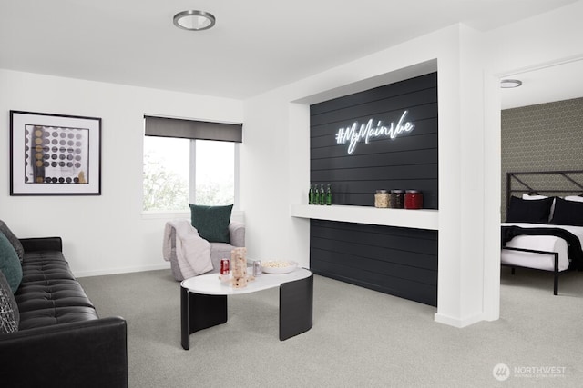 carpeted living area featuring baseboards