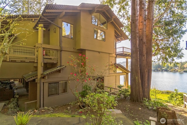 181 N Bay Ln Unit 2, Port Ludlow, WA 98365 - view of home's exterior with a water view, stucco siding, and a balcony