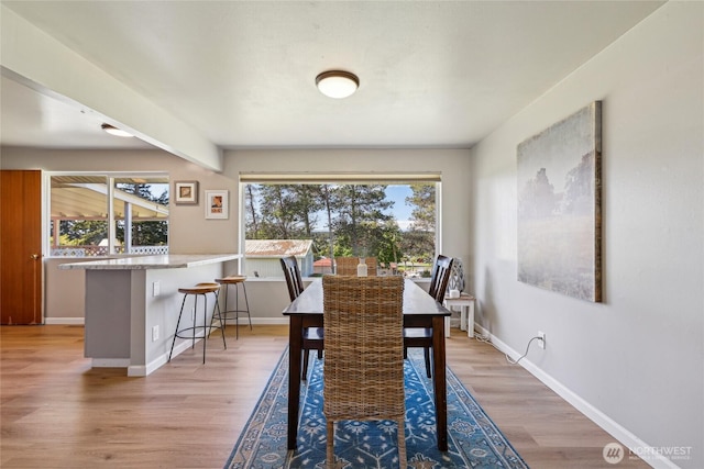 dining room with light wood-type flooring and baseboards