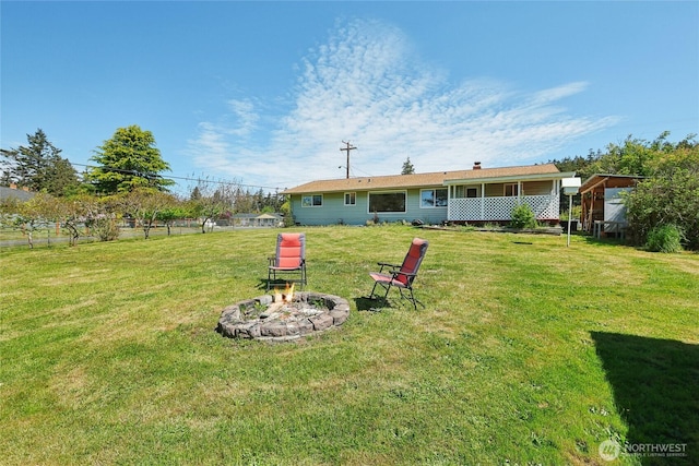 view of green lawn with a fire pit