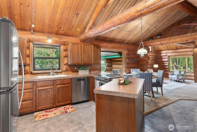1321 E Smith Rd, Bellingham, WA 98226 - kitchen featuring stainless steel appliances, a sink, rustic walls, healthy amount of natural light, and brown cabinetry