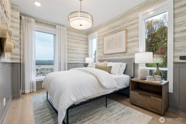 bedroom featuring wallpapered walls and wood finished floors