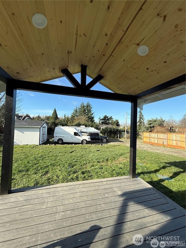 wooden terrace with a yard, fence, an outbuilding, and a shed