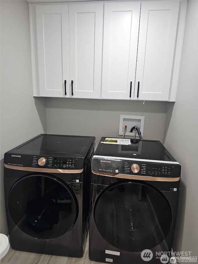 laundry room with separate washer and dryer and cabinet space