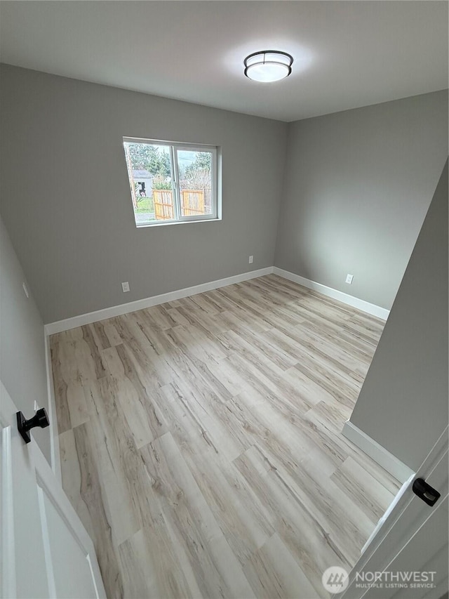 empty room featuring baseboards and wood finished floors