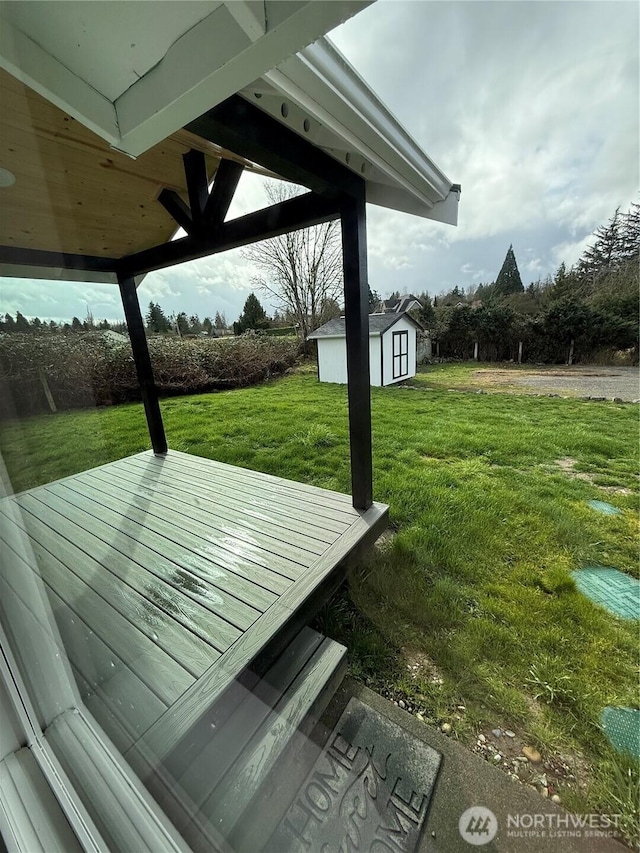 exterior space featuring an outbuilding, a wooden deck, and a storage shed