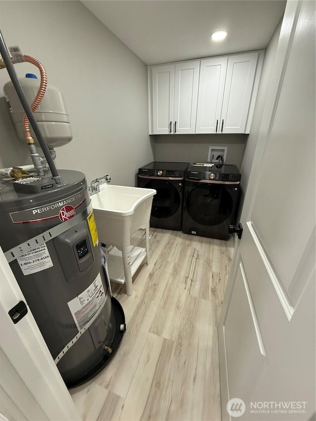 washroom with washing machine and dryer, recessed lighting, cabinet space, electric water heater, and light wood finished floors