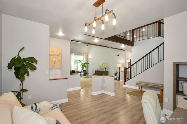 living room with baseboards, stairway, and light wood-style floors