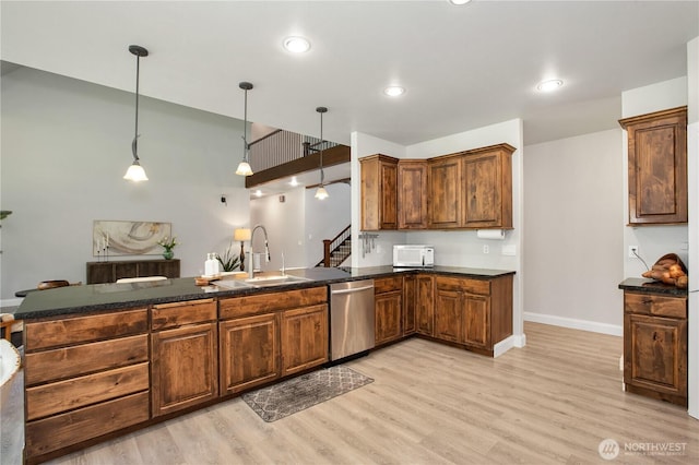 kitchen with dark countertops, white microwave, a sink, and dishwasher