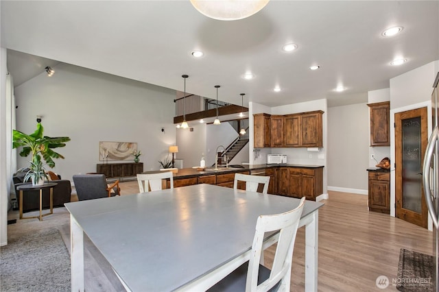dining area featuring recessed lighting, baseboards, stairway, and light wood-style floors