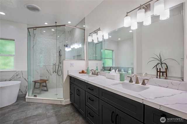 full bath with double vanity, a shower stall, and a sink
