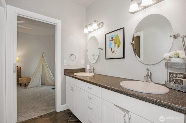 full bath with double vanity, a sink, and tile patterned floors