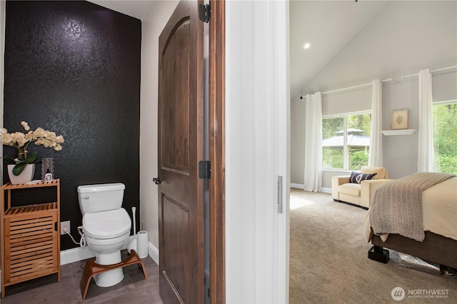 bathroom with toilet, baseboards, vaulted ceiling, and ensuite bath