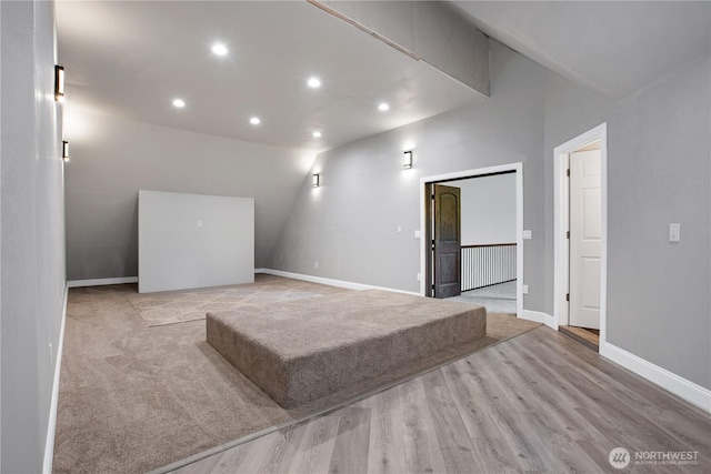 spare room featuring recessed lighting, baseboards, wood finished floors, and vaulted ceiling