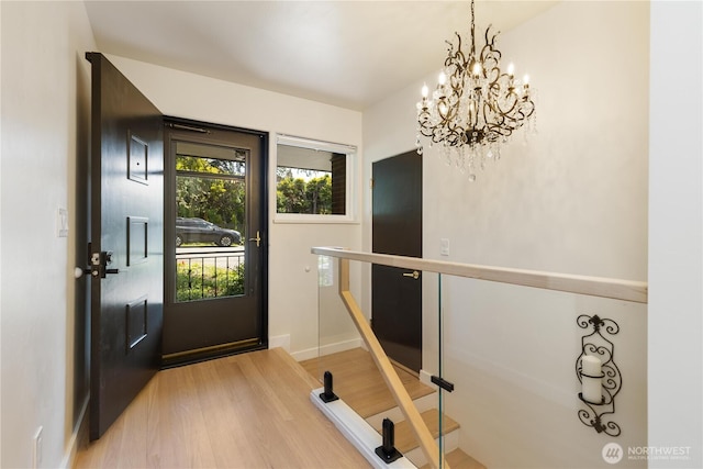 interior space with light wood-type flooring, baseboards, and a chandelier