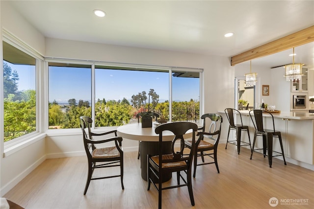 dining room featuring recessed lighting, light wood finished floors, baseboards, and a notable chandelier