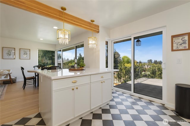 kitchen with baseboards, recessed lighting, light countertops, dark floors, and a notable chandelier
