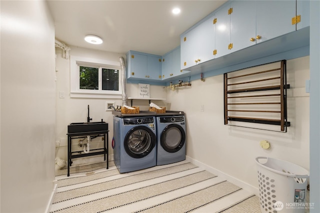 washroom featuring cabinet space, baseboards, washing machine and dryer, and radiator