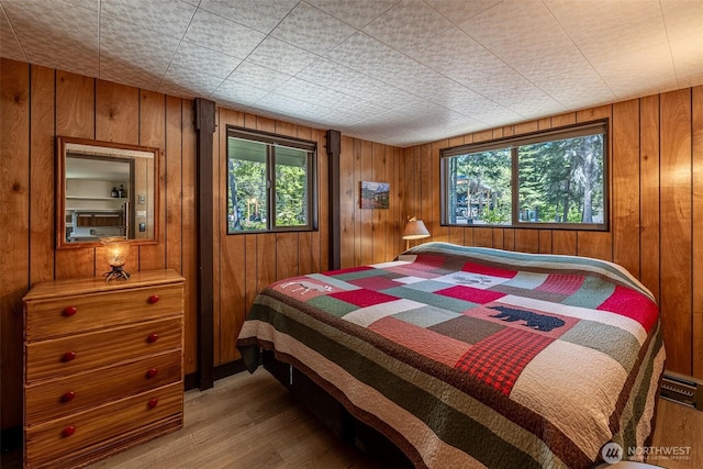 2684 Cedar Crst, Leavenworth, WA 98826 - bedroom featuring multiple windows, wood walls, and wood finished floors