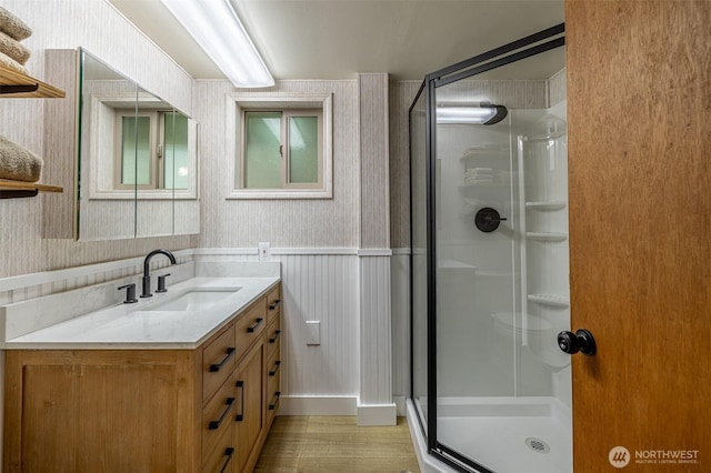 2684 Cedar Crst, Leavenworth, WA 98826 - bathroom with wallpapered walls, a stall shower, vanity, wood finished floors, and wainscoting