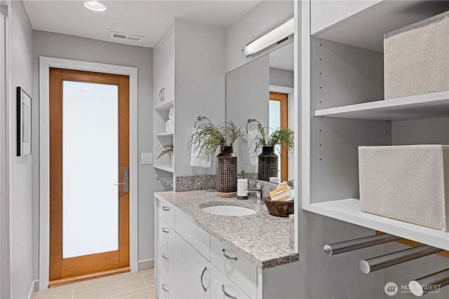 bathroom with visible vents, baseboards, and vanity
