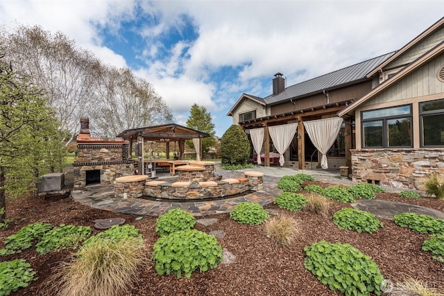 view of yard featuring an outdoor stone fireplace, a gazebo, and a patio area