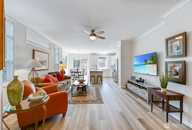 living area with light wood finished floors, crown molding, ceiling fan with notable chandelier, and recessed lighting