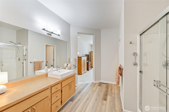full bath featuring vanity, baseboards, a shower stall, and wood finished floors