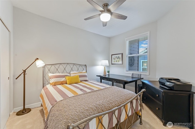 bedroom with light colored carpet, a closet, baseboards, and ceiling fan