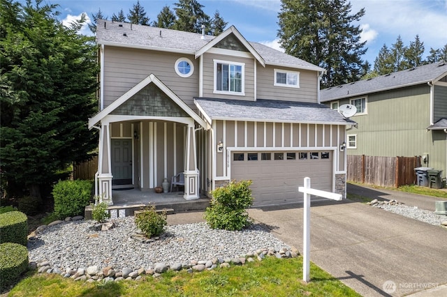 view of front of house featuring covered porch, fence, an attached garage, driveway, and board and batten siding