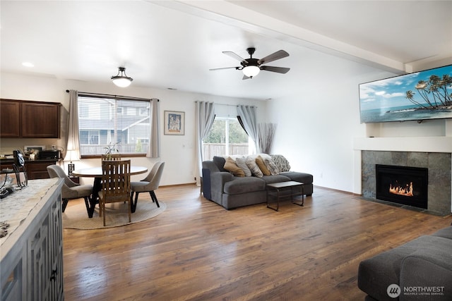 living area with a ceiling fan, a fireplace, and wood finished floors