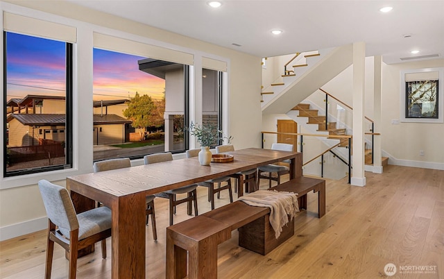 dining room featuring baseboards, recessed lighting, light wood-style floors, and stairway