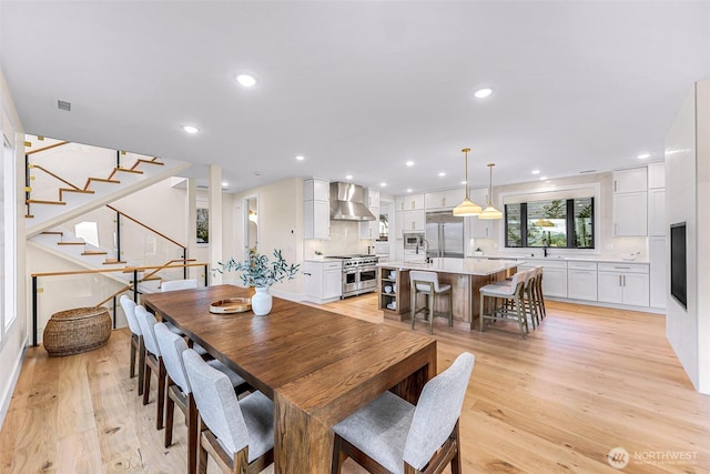 dining space featuring light wood-style floors, stairway, recessed lighting, and visible vents