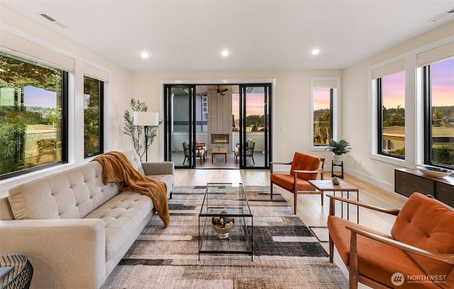 living area with visible vents, recessed lighting, wood finished floors, and a wealth of natural light