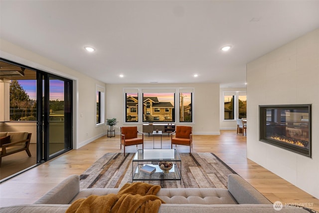 living area featuring light wood-type flooring, recessed lighting, and a tile fireplace