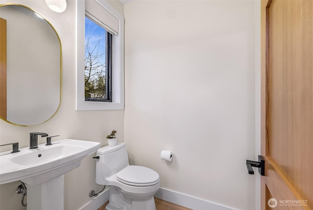 bathroom featuring baseboards and toilet