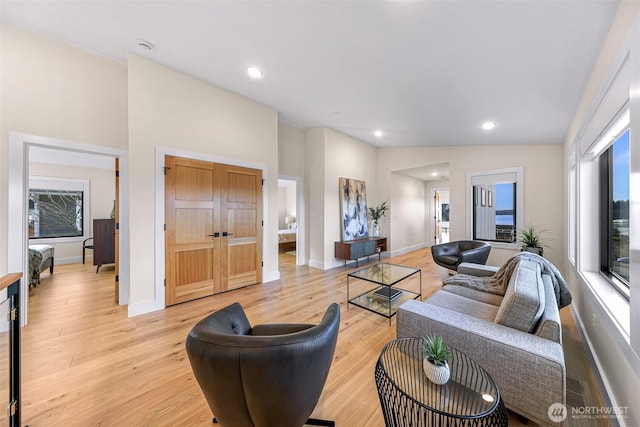 living area with recessed lighting, light wood-style flooring, and baseboards