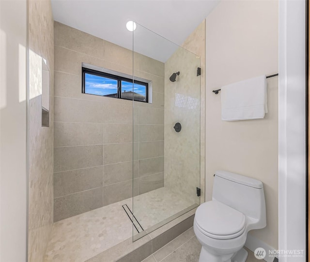 bathroom with tile patterned flooring, walk in shower, and toilet