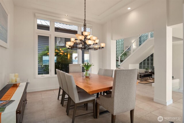 dining area featuring a chandelier, light tile patterned floors, recessed lighting, a high ceiling, and baseboards