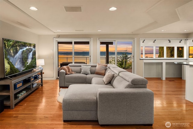 living area with recessed lighting and light wood-style floors