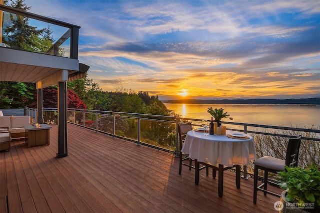 deck at dusk featuring a water view and an outdoor hangout area