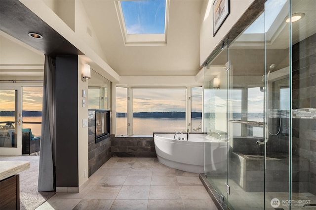 full bathroom featuring plenty of natural light, a soaking tub, a stall shower, a skylight, and recessed lighting