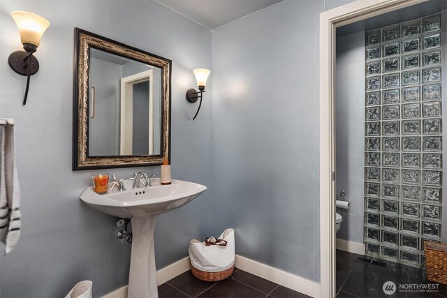 bathroom with tile patterned floors, baseboards, and toilet