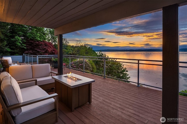 deck featuring a water view and an outdoor living space with a fire pit