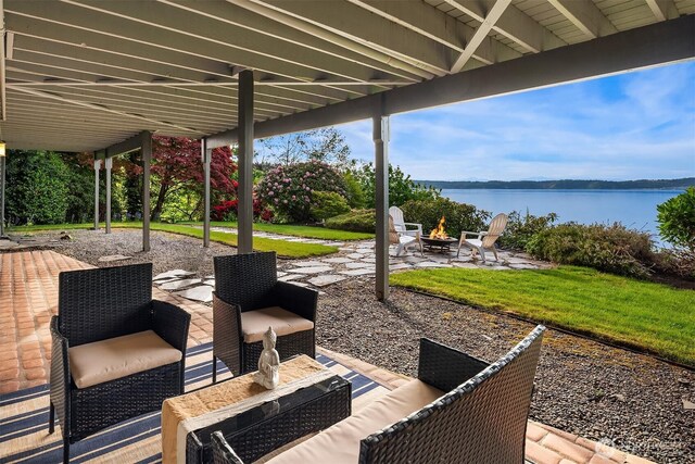 view of patio featuring a water view and an outdoor living space with a fire pit