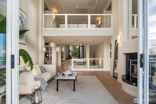 tiled living area featuring a towering ceiling