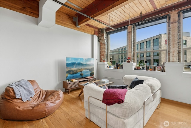 living area featuring wooden ceiling, wood finished floors, and beam ceiling