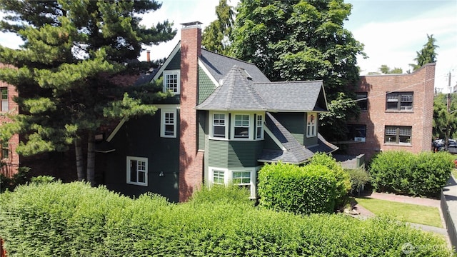 view of front of property featuring a shingled roof and a chimney