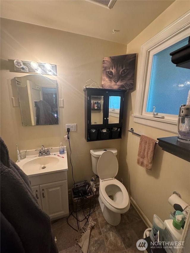 bathroom with toilet, visible vents, baseboards, and vanity
